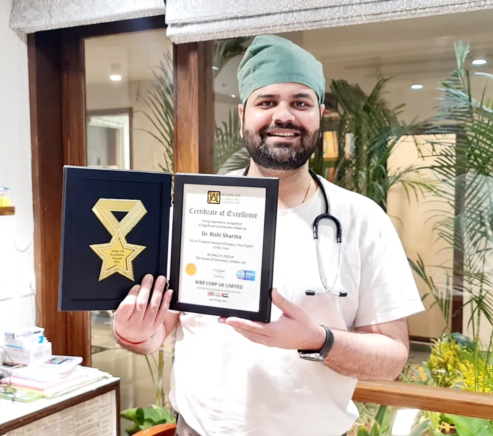 Dr. Rishi Sharma holding the Certificate of Excellence